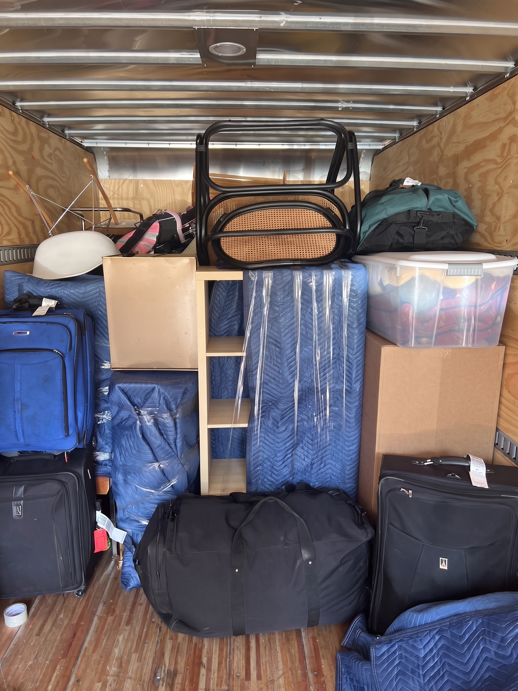 Moving truck loaded with wrapped furniture, boxes and luggage